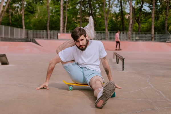 스케이트보드를 사용하여 옥외에서 스트레칭하는 젊은이 — 스톡 사진