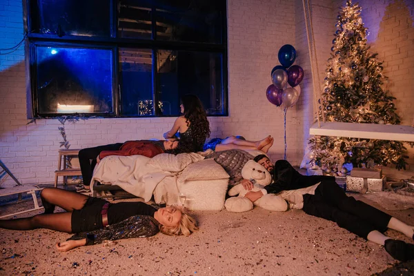 Grupa przyjaciół po przyjęciu świątecznym w domu śpiących razem na łóżku i na podłodze mieli ciężką i ekscytującą noc — Zdjęcie stockowe