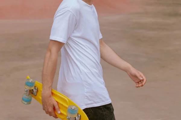 스케이트 보드를 들고 포즈를 취하고 있는 젊은 남자의 모습 — 스톡 사진
