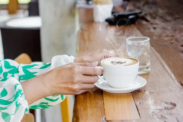 Mão feminina segurando xícara de café — Fotografia de Stock