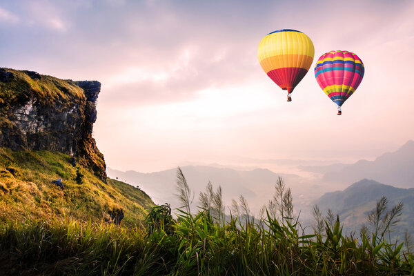 Разноцветные воздушные шары, летящие над горой