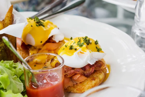 Ägg benedict - rostade engelska muffins, skinka, pocherat ägg och läcker smörig hollandaisesås — Stockfoto