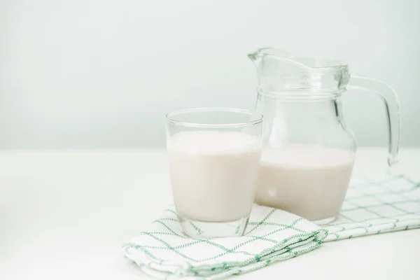 Bir cam sürahi ve bardak ahşap arka plan üzerinde süt