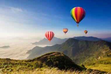 Dağın üstünden uçan renkli sıcak hava balonu