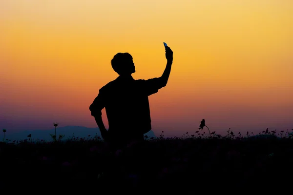 남자 selfie의 실루엣입니다. 일몰 하늘에서 포즈 하는 남자의 실루엣 — 스톡 사진