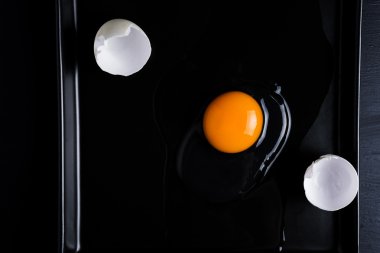 Yumurta ve kabuk siyah bir plaka üzerinde kırık