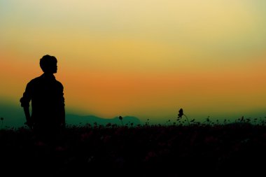 Günbatımı gökyüzü arka plan poz adam silüeti.