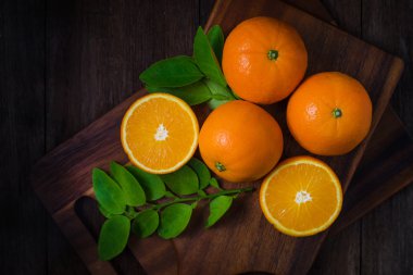 Ahşap arka plan üzerinde taze organik portakal meyveler.