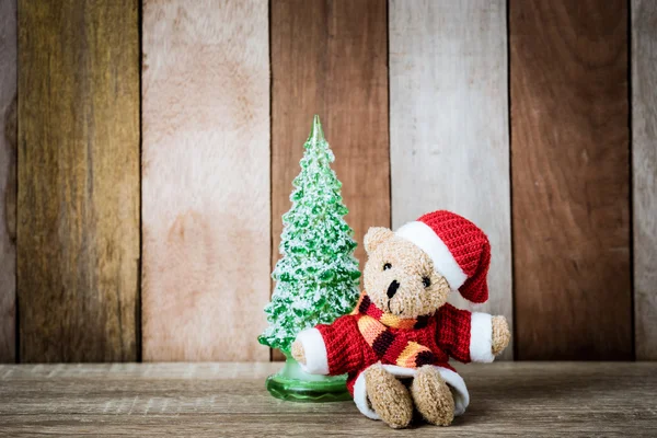 Vánoční ozdoba medvídek a vánoční strom na dřevěné bac — Stock fotografie