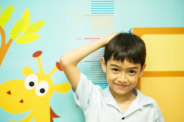 Pequeño niño comprobando su altura en el hospital — Foto de Stock