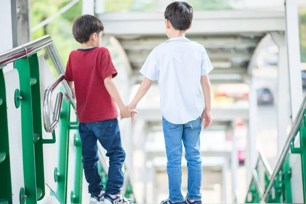 Piccolo fratello ragazzo scendendo la scala stazione ferroviaria pubblica — Foto Stock