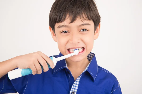 Küçük çocuk beyaz arka plan üzerinde elektrikli diş fırçaları kullanarak — Stok fotoğraf