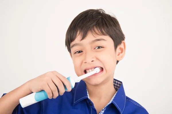 Menino usando escovas de dentes elétricas no fundo branco — Fotografia de Stock