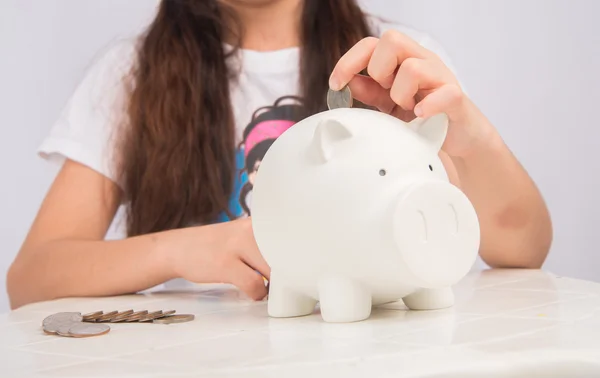 Little girl saving money in piggy bank — Stock Photo, Image