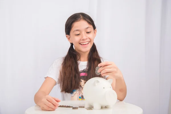Little girl saving money in piggy bank — Stock Photo, Image