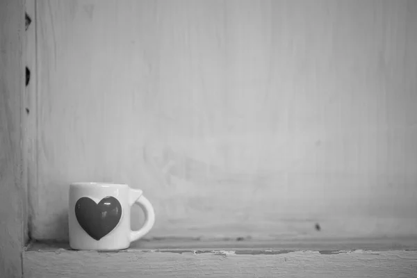 Small cup in the corner of the wall black and white — Stock Photo, Image