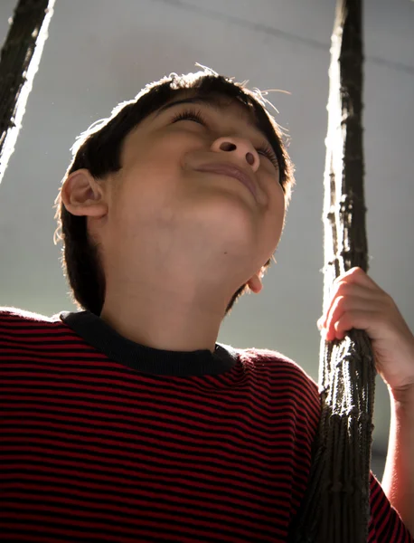 Niño jugando swing interior llanta luz blanco y negro — Foto de Stock