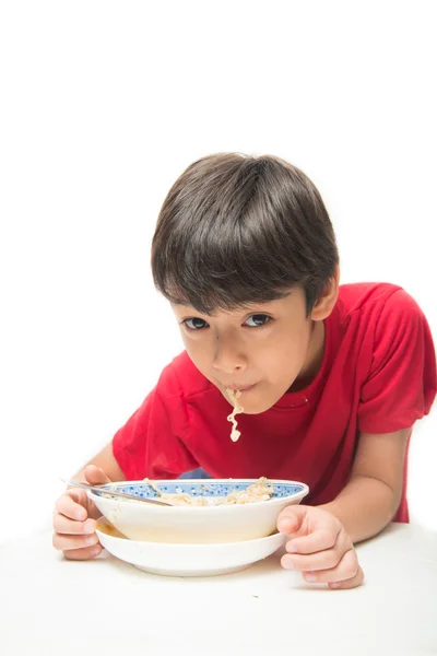 Kleine jongen eten instant noodle op witte achtergrond — Stockfoto