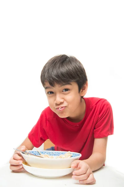 Kleine jongen eten instant noodle op witte achtergrond — Stockfoto