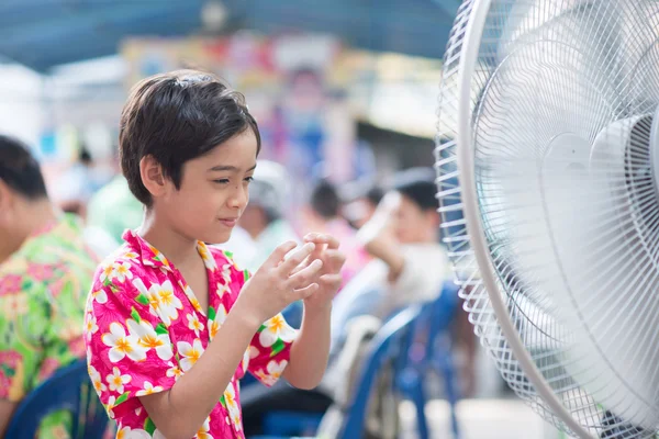 Μικρό αγόρι μπροστά από ηλεκτρικό ανεμιστήρα, το ζεστό καλοκαίρι — Φωτογραφία Αρχείου