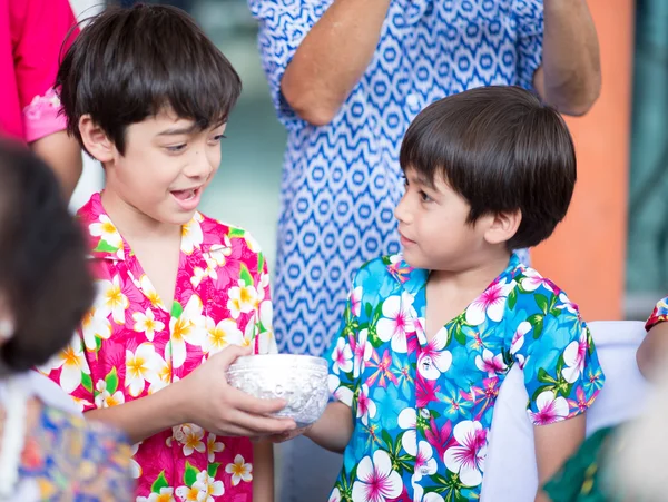 Little sibling boy taking a bowl for playing water in water festival together — Stock Photo, Image