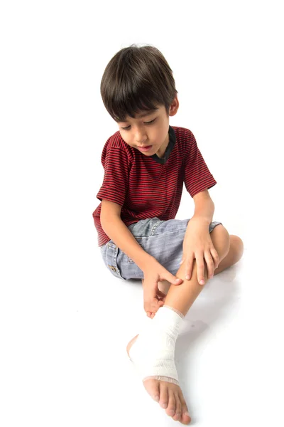 Kleine jongen heeft een ongeval met zijn been, bandage voor eerste hulp nodig — Stockfoto