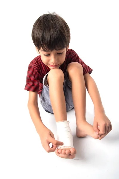 Kleine jongen heeft een ongeval met zijn been, bandage voor eerste hulp nodig — Stockfoto