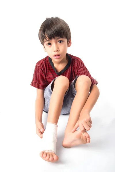 El niño tiene un accidente con su pierna necesita vendaje para primeros auxilios — Foto de Stock