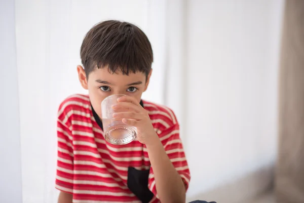 Petit garçon eau potable maison intérieure — Photo