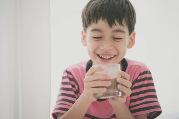 Мальчик пьет молоко винтажного цвета — стоковое фото
