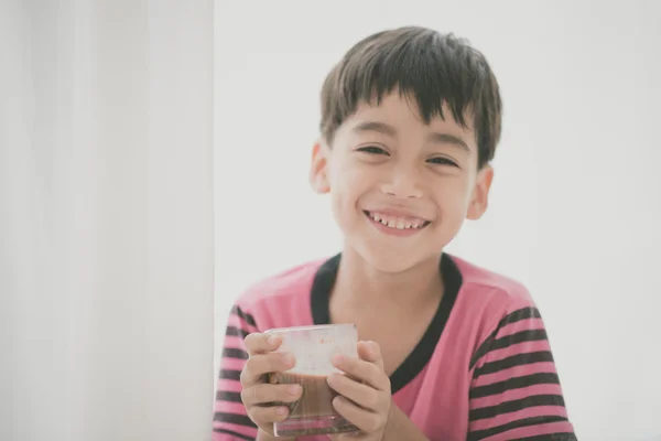 Маленький хлопчик п'є молоко вінтажного кольору — стокове фото