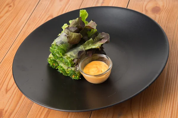 Ensalada de rollo de algas en plato negro — Foto de Stock