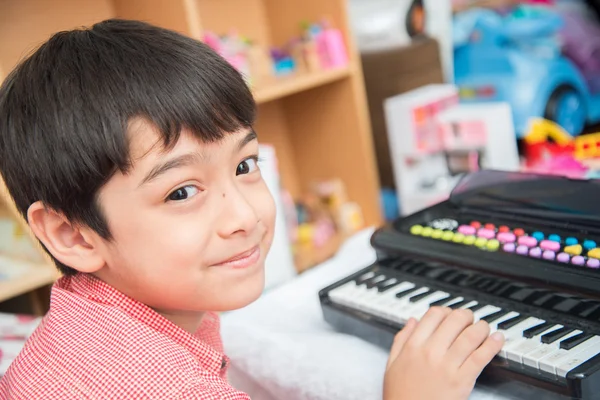 Pequeño chico de la mano jugando pequeño teclado práctica — Foto de Stock