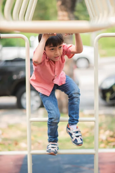 Kleiner Junge spielt auf Spielplatz beim Klettern — Stockfoto