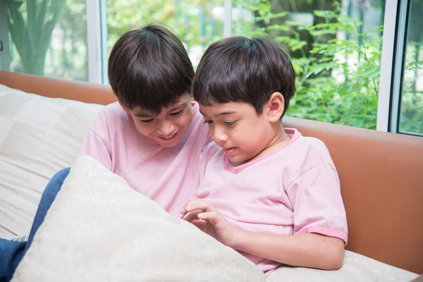 Little sibling boy playing game on mobile tablet together — Stock Photo, Image