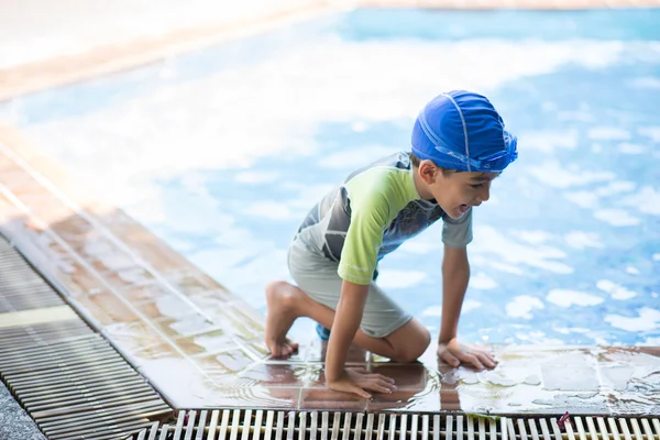 Маленький мальчик учится в классе плавания с учителем в бассейне со счастливым лицом — стоковое фото