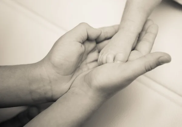 Cerca de los pies del bebé recién nacido en blanco y negro color cremoso — Foto de Stock