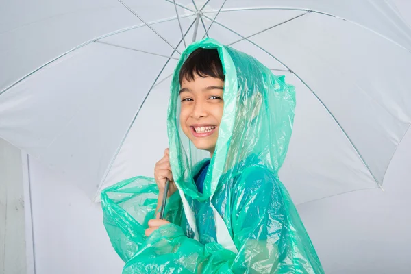 Мальчик в дождевике на белом фоне — стоковое фото
