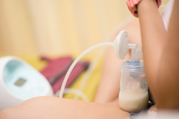 Мати робить електронне годування грудей для свого запасу молока — стокове фото