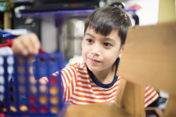 Little boy playing connect four game soft focus at eye contact — Stock Photo, Image