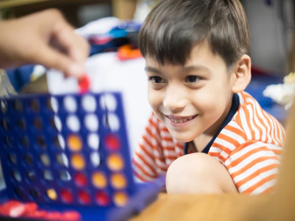 Little boy playing connect four game soft focus at eye contact — Stock Photo, Image