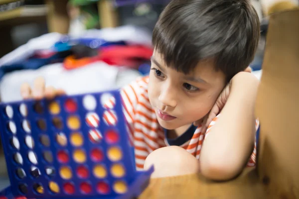 Kleine jongen spelen verbind vier spel Softfocus bij contact met de ogen — Stockfoto