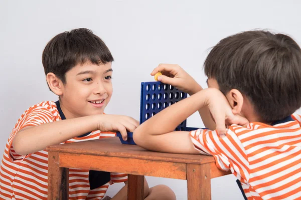 Liten pojke spelar ansluta fyra spel mjukt fokus på ögonkontakt — Stockfoto