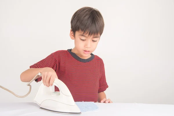 Menino engomando seu pano ajudando do trabalho em casa — Fotografia de Stock