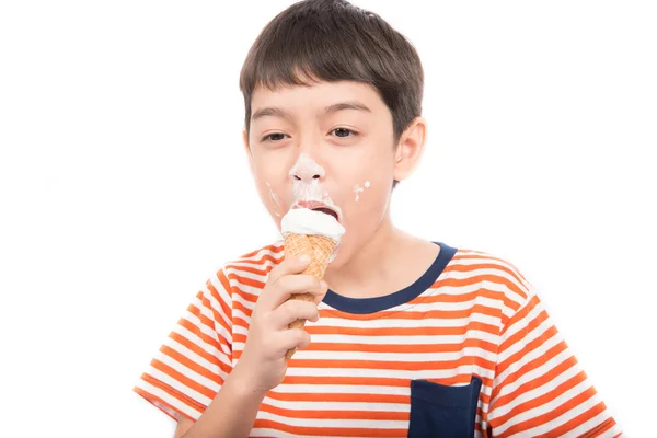 Мальчик ест шоколадное мороженое со счастливым лицом в летнее время — стоковое фото