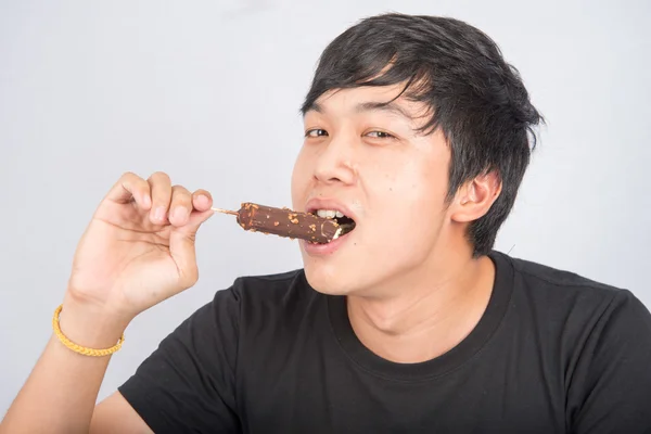 Aziatische tiener mannetje eten chocolade ijs met blij gezicht zomertijd — Stockfoto