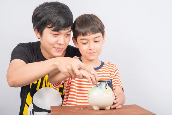 Aziatische tiener mannelijke telg het geld besparen in piggy bank — Stockfoto