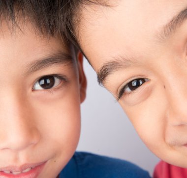 Kardeş kardeşi birlikte gülümseyen gözünü kapat