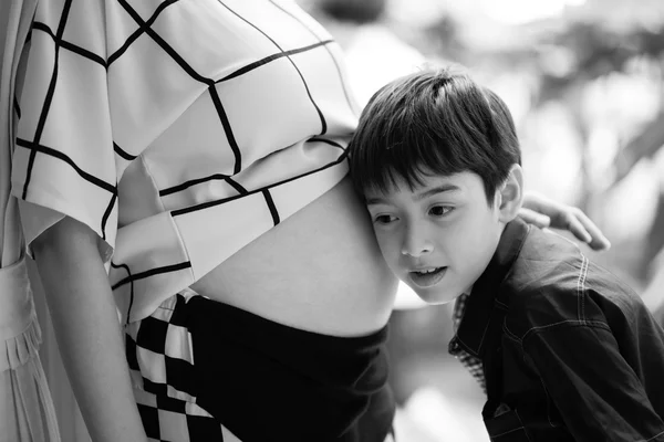 Pequeño niño escuchar madre vientre embarazo wating para nuevo bebé — Foto de Stock