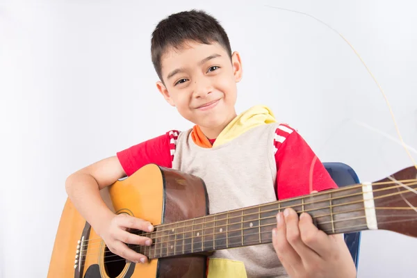 Kleiner Junge spielt klassische Gitarre auf weißem Hintergrund — Stockfoto